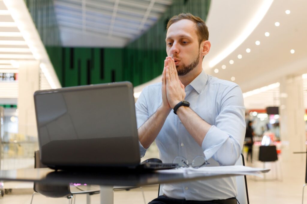 Mann praktiziert Atemtechnik am Arbeitsplatz.