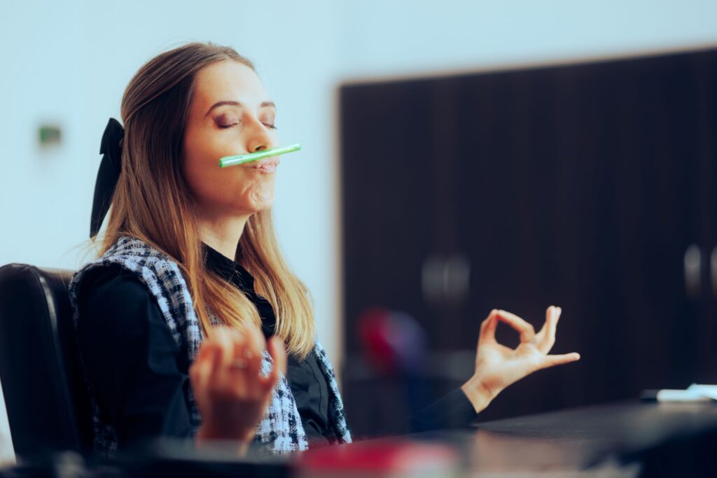 Frau mit Meditationspose im Büro zur Entspannung.